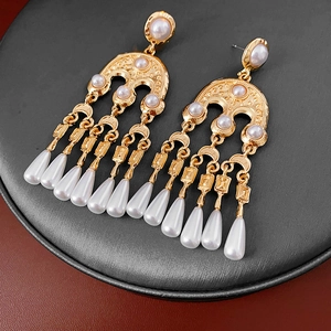 Detail of vintage round pearl earrings with hanging teardrop pearl tassels in gold