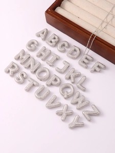 Close-up of silver bubble initial letter pendants with micro-pave cubic zirconia crystals