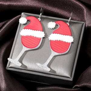 Detailed close-up of acrylic Christmas wine glass earrings with red hat and glitter