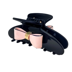 Elegant black acetate hair claw clip with pink bows and gold accents on white background