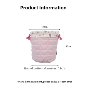 Detailed view of pink drawstring storage bag with heart quilting and floral pattern