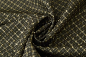 Close-up of dark plaid fabric texture with elegant spiral folds and fine weave details