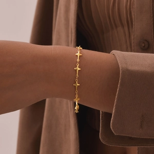 Elegant gold stainless steel bracelet featuring delicate star charms on female wrist