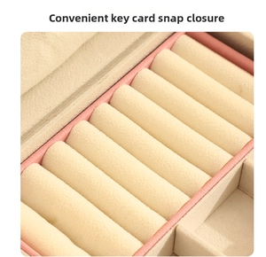 Detail view of pink leather jewelry box with velvet slots and key buckle closure
