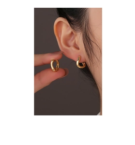Dettaglio orecchini asimmetrici in argento placcato oro 14K a forma di U indossati