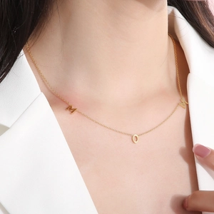 Close-up of gold MOM pendant necklace on model's neck for a vintage mother's day look