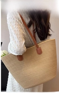 Detailed view of woven cotton rope tote bag with durable brown leather handles