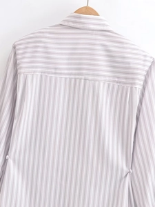 Close-up of grey and white striped long sleeve shirt with back shoulder panel detail
