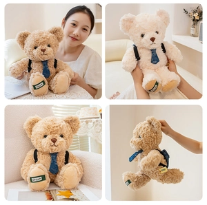 Detail view of teddy bear plush toy with floral tie and mini backpack accessory