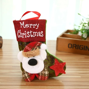 Detail of red Christmas stocking with plush bear mascot and festive plaid bow decoration