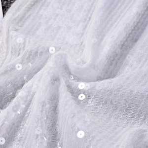 Gros plan sur le tissu en maille blanche avec paillettes brillantes pour pantalon femme