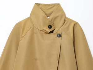 Detailed close-up of khaki trench coat collar with black resin buttons and twill texture