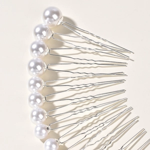Close-up of pearl U-shaped hair pins with polished silver alloy for wedding hair