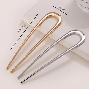 Close-up of sleek gold and silver U-shaped metal hair pins with size and weight details