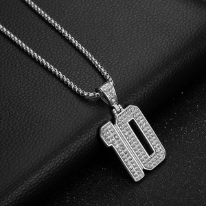 Detailed view of silver number 10 pendant with sparkling rhinestones on leather background