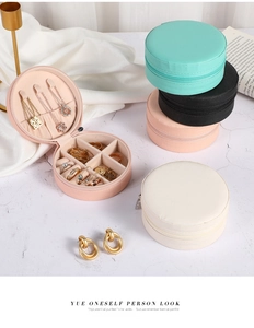 Detail of round travel jewelry box interior with necklace hooks and ring slots
