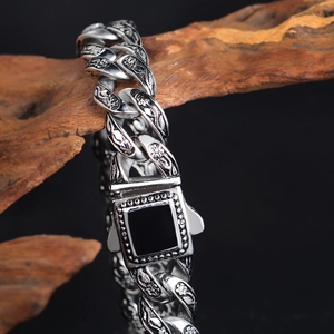 Dettaglio bracciale vintage in acciaio con incisioni a rosa e chiusura in gemma nera