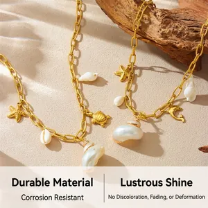 Detail of gold nautical necklace with starfish and turtle charms on sandy beach background