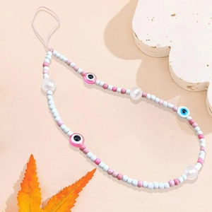 Pink and blue glass seed bead phone charm with evil eye accents on a soft background
