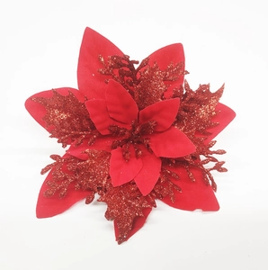 Close-up of red artificial poinsettia with layered fabric petals and festive gold glitter