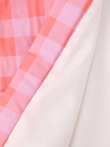 Close-up of pink plaid and white fabric stitching showing fine seam craftsmanship