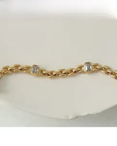 Detailed macro view of 18K gold plated brass link bracelet with sparkling rectangle zircons