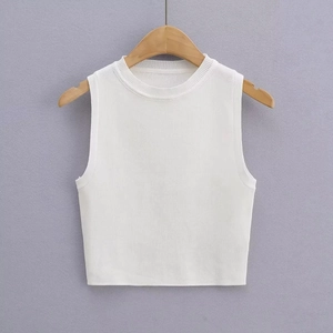 Detailed close-up of white ribbed knit crop top texture on a wooden hanger