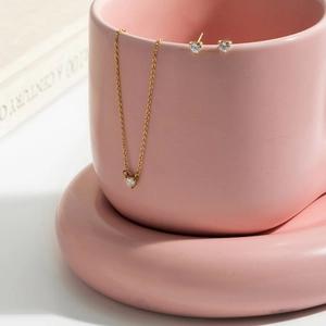 Dettaglio della collana placcata oro 18K e orecchini a cuore in zircone su ceramica