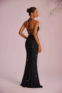 Detail of elegant black sequin evening gown showing the backless halter design with ties