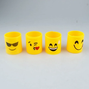 Detail shot of four yellow plastic spring toys featuring various cute smiley face expressions