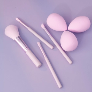 Detailed overhead view of 4 pink makeup brushes and 3 water-drop sponges set
