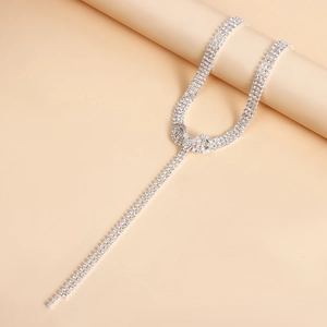 Macro shot of silver bow choker featuring three rows of sparkling crystal fringe tassels