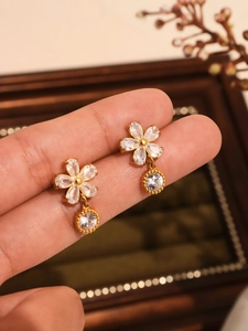 Détail macro de boucles d'oreilles fleurs en zircon 5A plaqué or 18 carats avec pendentifs