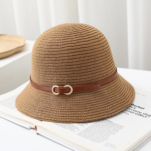 Detail of light brown cloche sun hat featuring a faux leather band and gold buckle