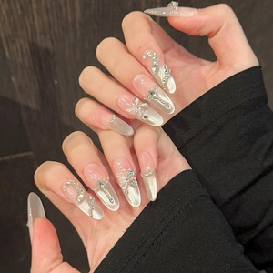 Détails de faux ongles faits main avec nœuds papillon argentés et effet œil de chat chic