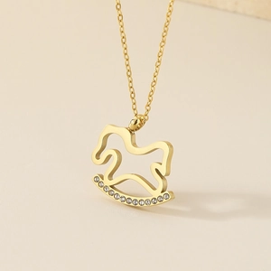 Close-up of golden rocking horse pendant with sparkling rhinestones on an O-chain