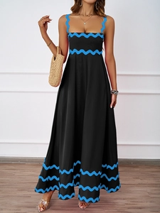 Detail of the elegant black vacation dress featuring contrasting blue wavy embroidered trim