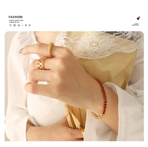 Close-up of elegant gold ring set and luxury red zircon bracelet on model's wrist