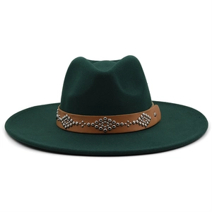 Detail of dark green wool fedora hat featuring a brown leather band with silver rivets