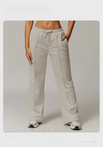 Detail of high-waist cream sweatpants showing elastic waistband with drawstring and vertical seams