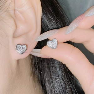 Macro shot of micro-pave heart stud earrings with cubic zirconia in 18k silver plating