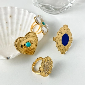 Bohemian gold ring set with turquoise heart, blue resin stone, and pearls on white shell