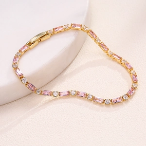 Close-up of gold-plated bracelet with pink baguette zircons and white round diamonds