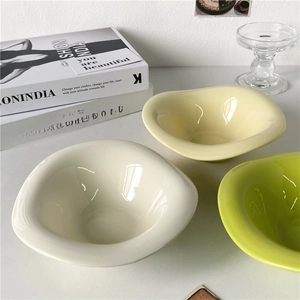 Tre ciotole da dessert irregolari in ceramica gialla, beige e verde su base bianca