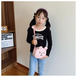 Pink plush rabbit crossbody bag for children shown on a wooden bookshelf background