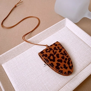 Macro shot of faux leather leopard print eyeglass case necklace with fine stitching details