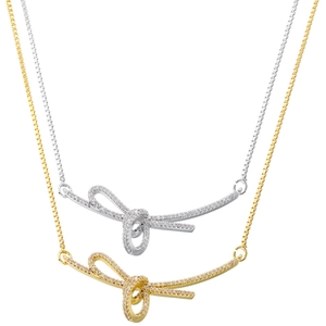 Detail view of gold and silver ribbon bow necklaces with sparkling cubic zirconia inlay