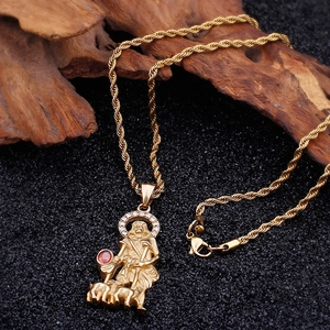 Macro detail of gold San Lazaro pendant with red stones and white crystals on a rope chain