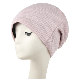 Detail of pink knit beanie showing texture and black lining on a white mannequin head