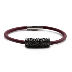 Macro detail of the dark red braided cord bracelet featuring a magnetic cross clasp